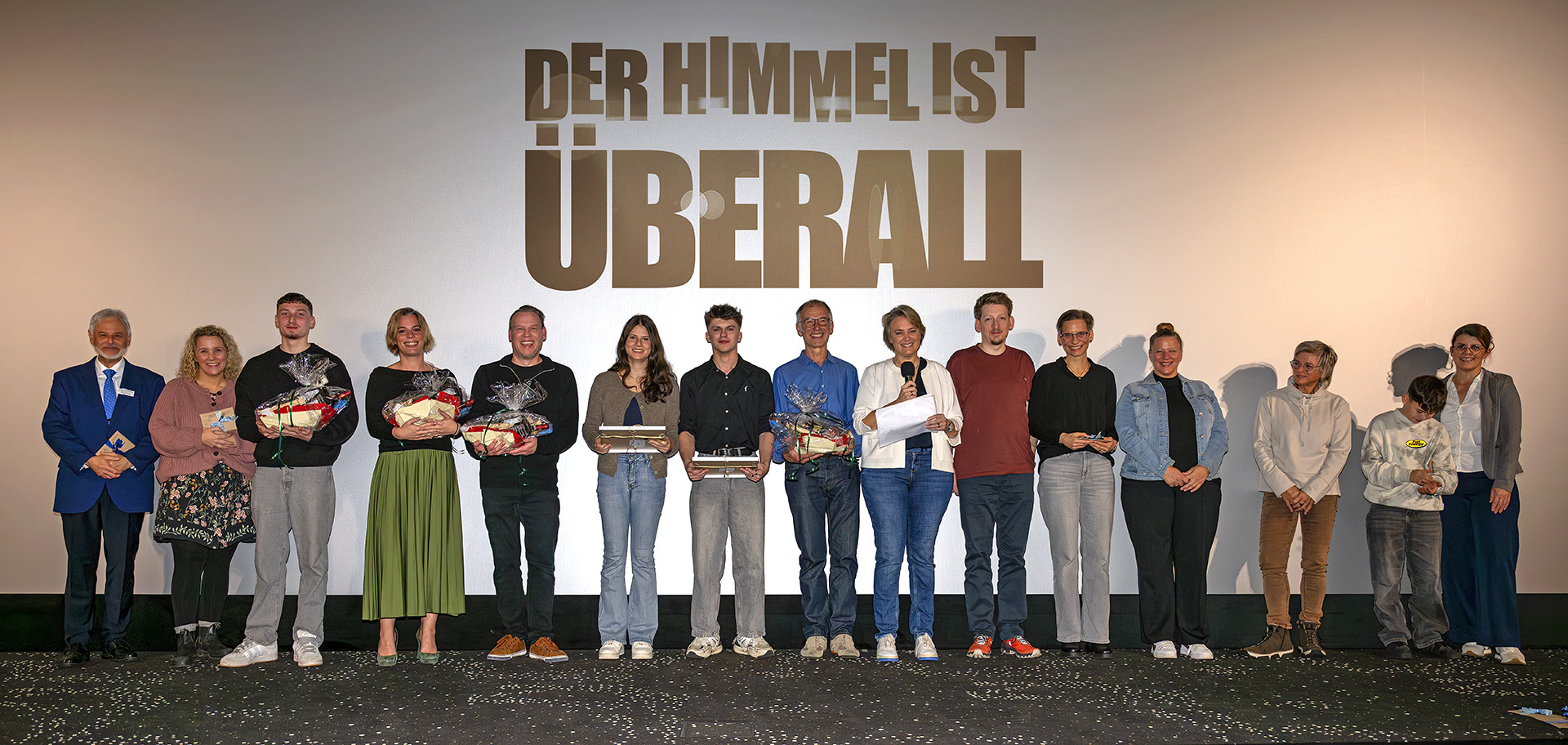 Alle Beteiligten des Films auf der Ehrung vor der Leinwand